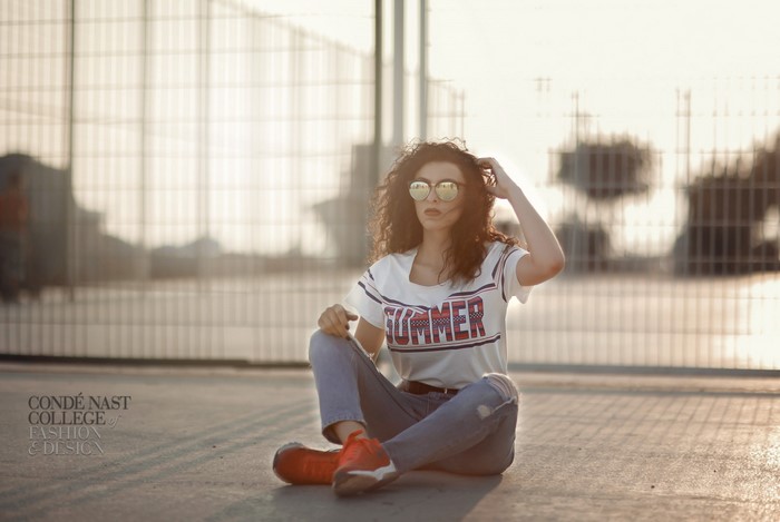 Woman in summer t-shirt and jeans sitting outdoors