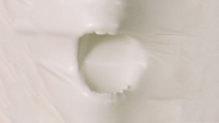 Close-up of a mouth with teeth through white material