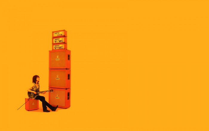 Man playing guitar with Orange amplifiers