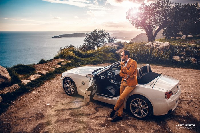 Man in orange suit with BMW Z4 by the sea