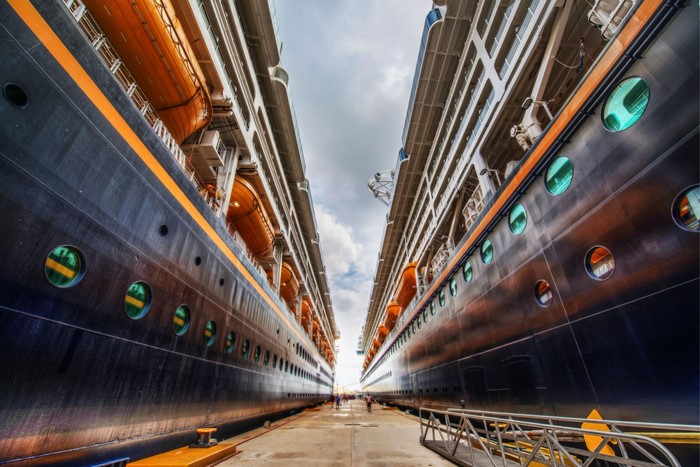 Two cruise ships docked side-by-side at a port