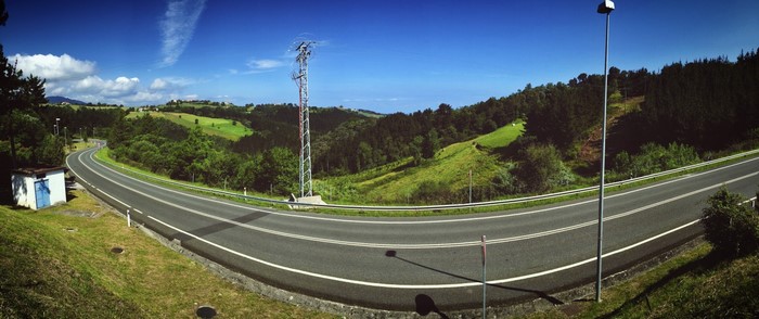 Panoramic view of a winding road through green hills in Spain