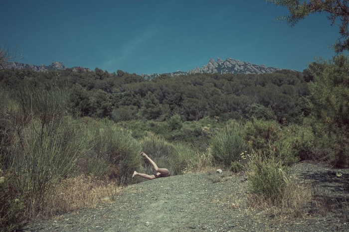 Person lying on a rocky path in a forest landscape