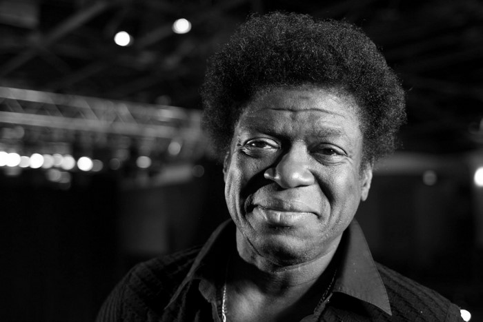 Charles Bradley, a man with curly hair, in monochrome portrait