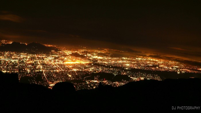 Cityscape at night with distant mountains