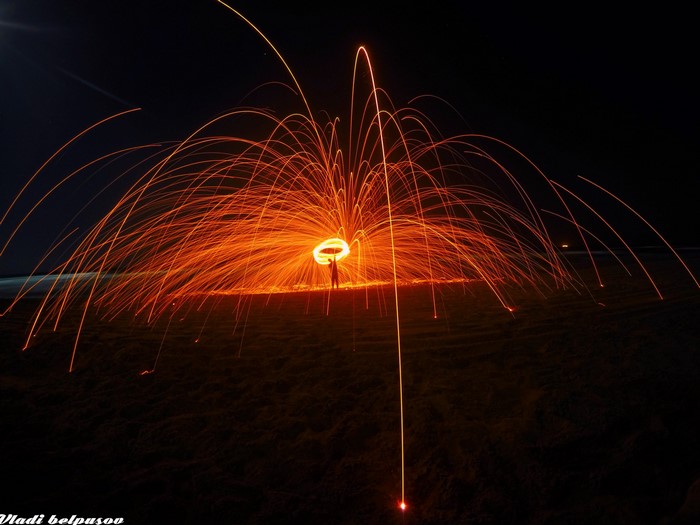 Person spinning burning steel wool at night