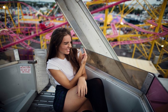 Woman in white top and plaid skirt on amusement ride