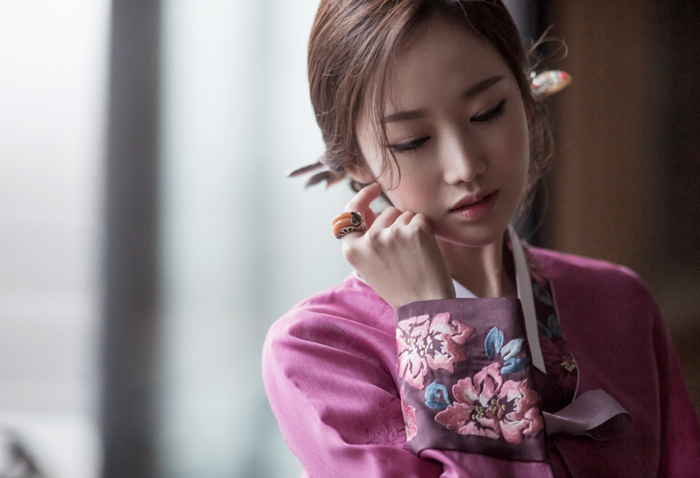 Woman in pink Hanbok with floral embroidery