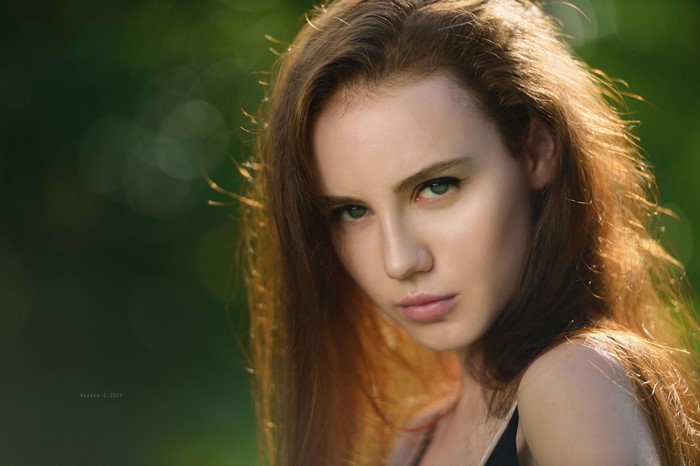 Portrait of a young woman with long brown hair and green eyes