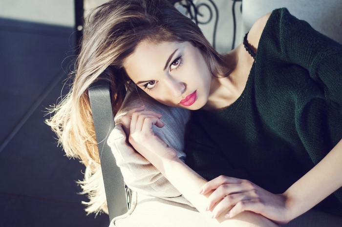 Woman with blonde hair wearing a green sweater