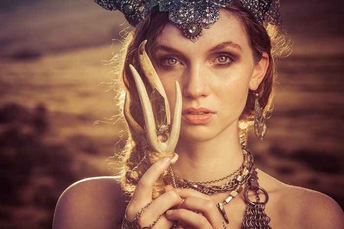 Woman with crown and antlers holding crystal