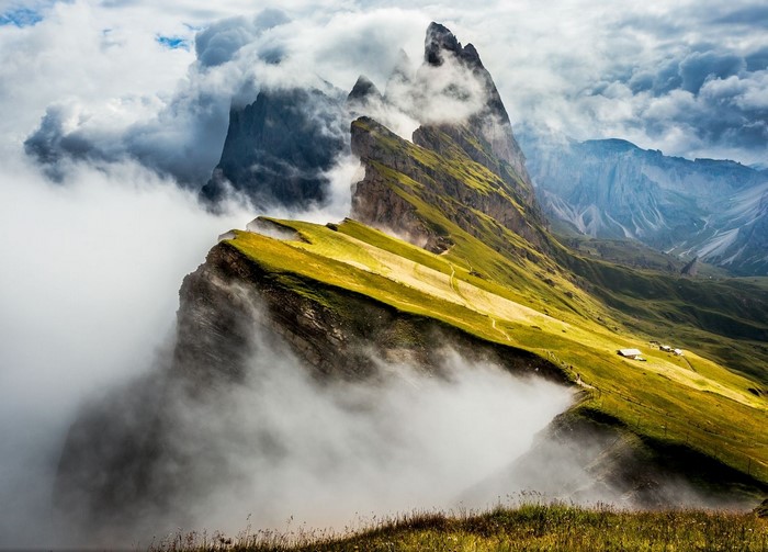 Mountain ridge with clouds and cabins in the Alps