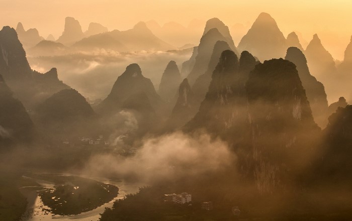 Misty mountains and river valley at sunrise
