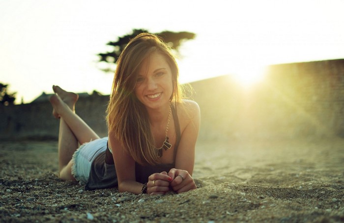 Woman lying on the beach at sunset