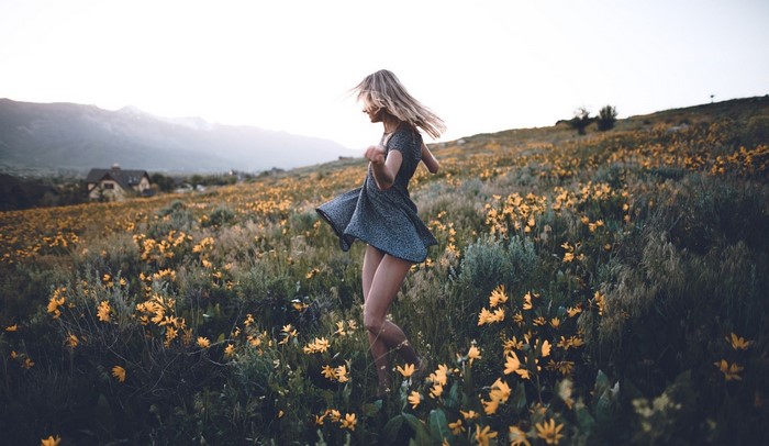Woman dancing in a field of yellow flowers