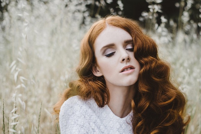 Woman with long wavy red hair in a white dress