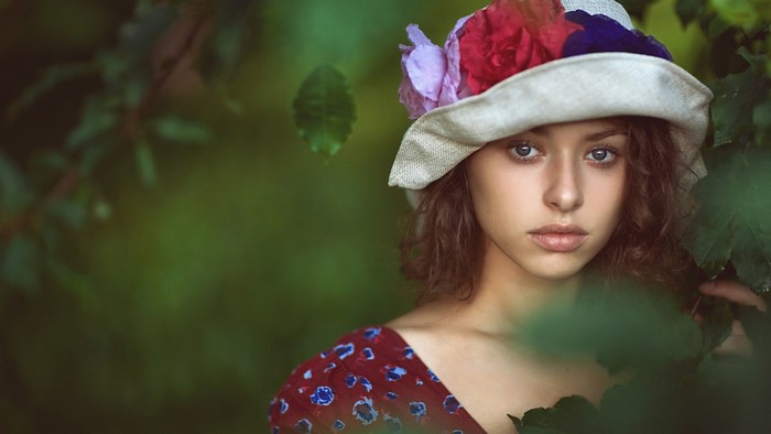 Woman wearing a hat with flowers in a garden