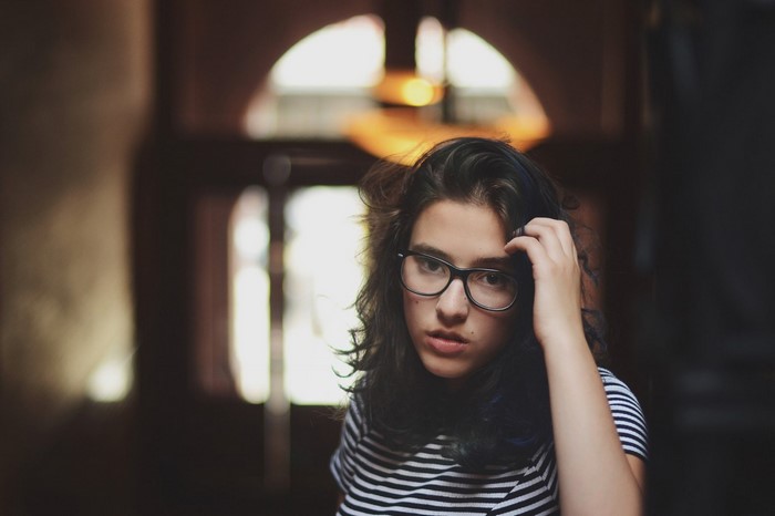 Woman with glasses touching her hair