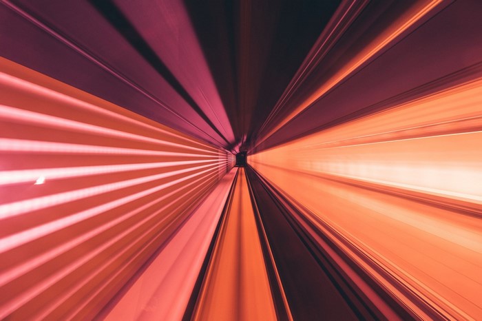 Light trails in a tunnel with red and orange hues