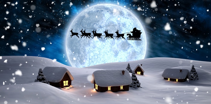Santa Claus flying with reindeer in the night sky over snowy village