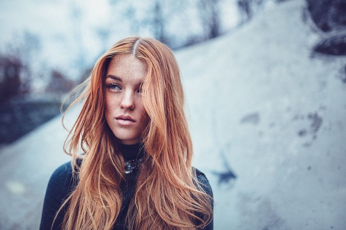 Woman with red hair and freckles looking away