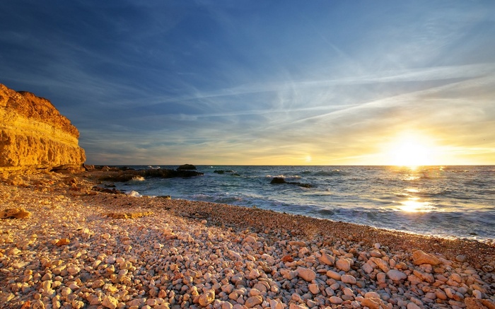 Sunset over a rocky beach and cliff