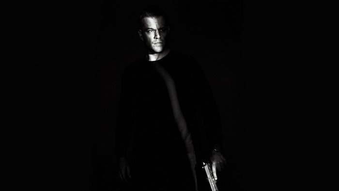 Matt Damon as Jason Bourne holding a gun