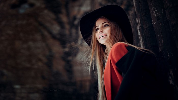 Woman in black hat and red jacket