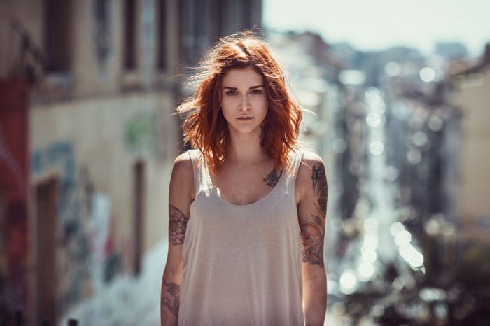 Woman with red hair and tattoos in a city