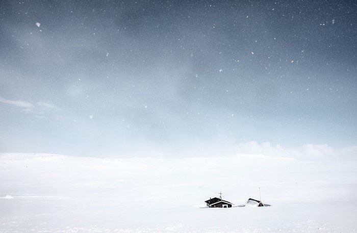 Two houses in a snowy landscape under a starry sky