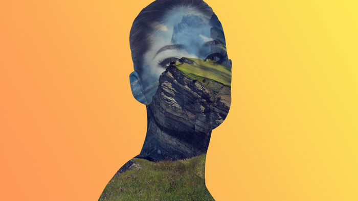 Double exposure of a woman's face with a mountain landscape