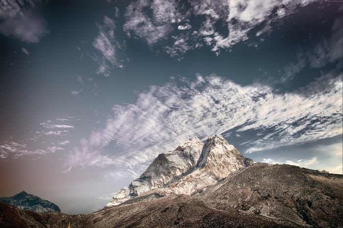Snow-capped mountains under a cloudy sky