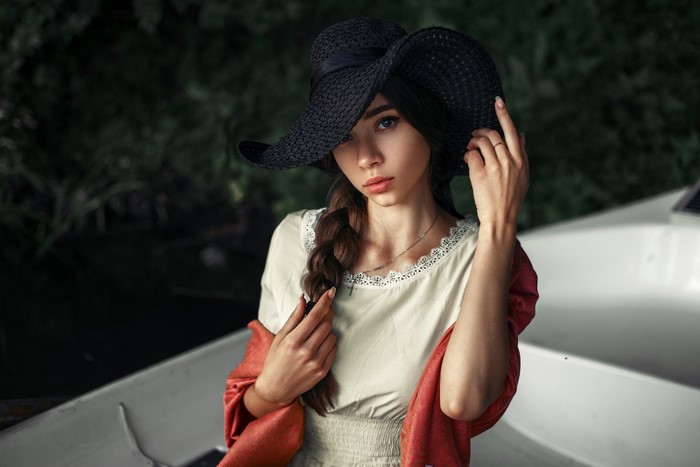 Woman in a black hat and red scarf in a boat