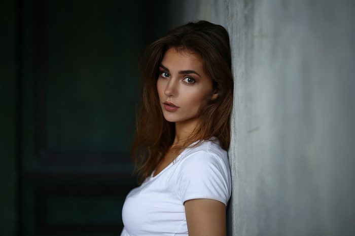 Brunette Woman in White T-shirt Leaning on Wall