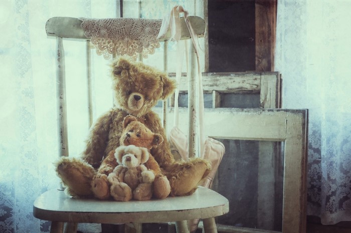Three teddy bears on a chair