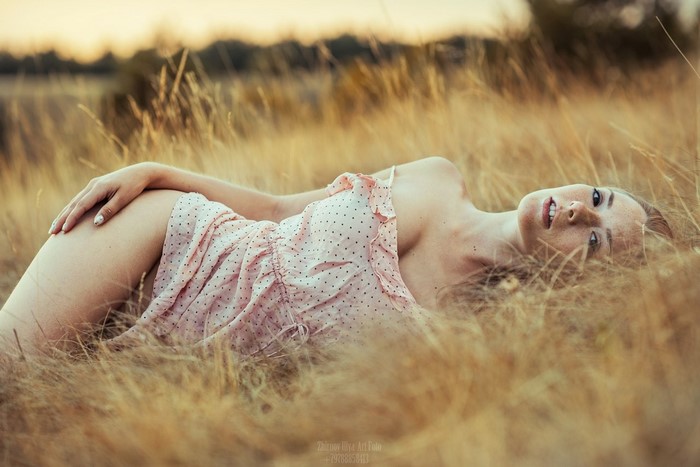 Woman Lying in a Golden Grass Field