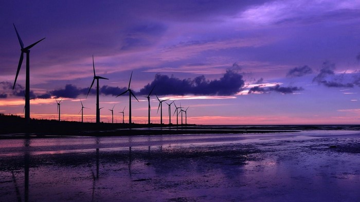 Wind turbines at sunset over the ocean