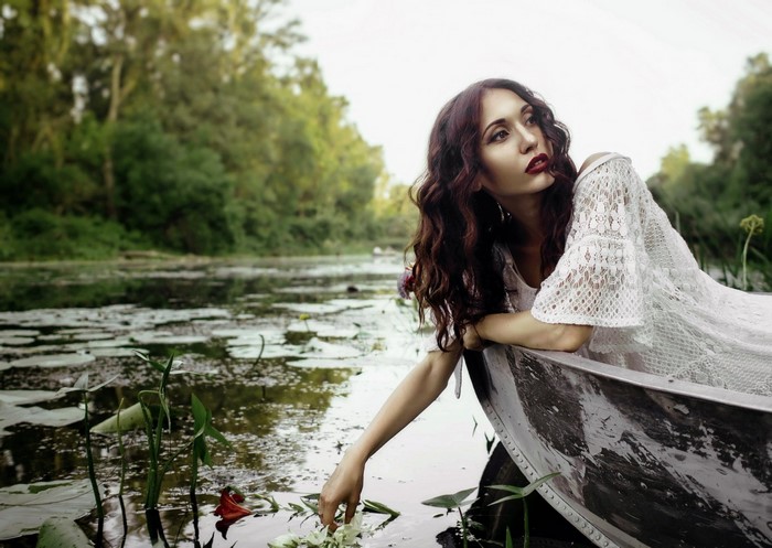 Woman in a white dress in a boat on a lake