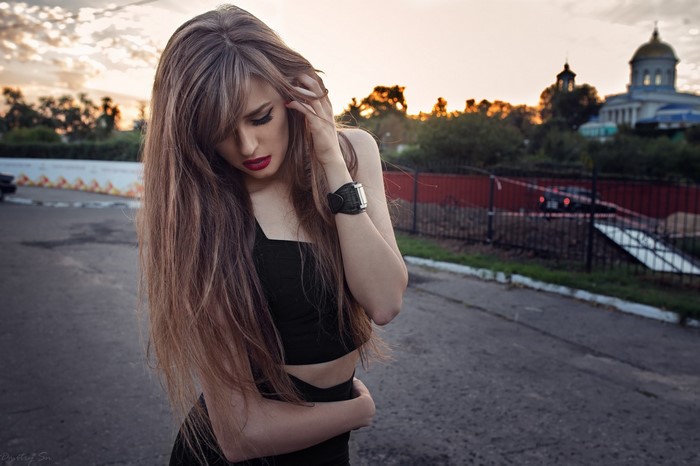 Woman with long brown hair and red lipstick outdoors