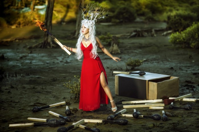 Woman in red dress holding a giant lit match