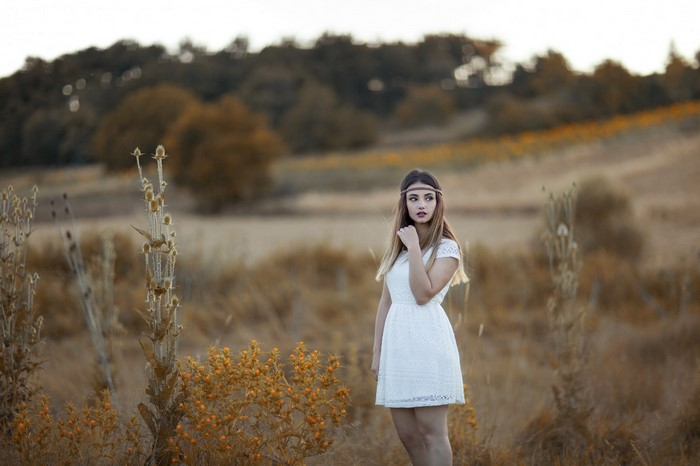 Woman in white dress with headband in a field