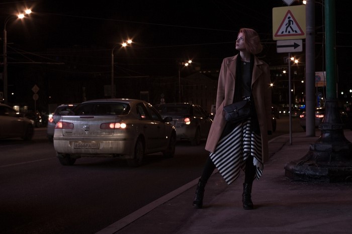 Woman with redhead hair on a city street at night