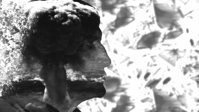 Double exposure of a man's profile and a mushroom cloud