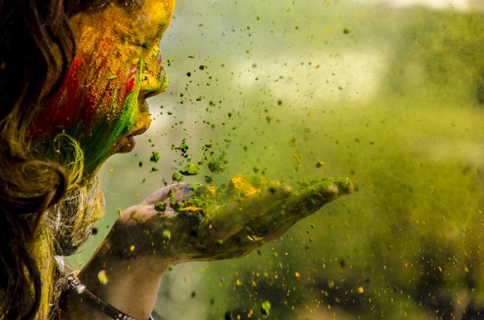 Woman blowing colorful powder during Holi festival