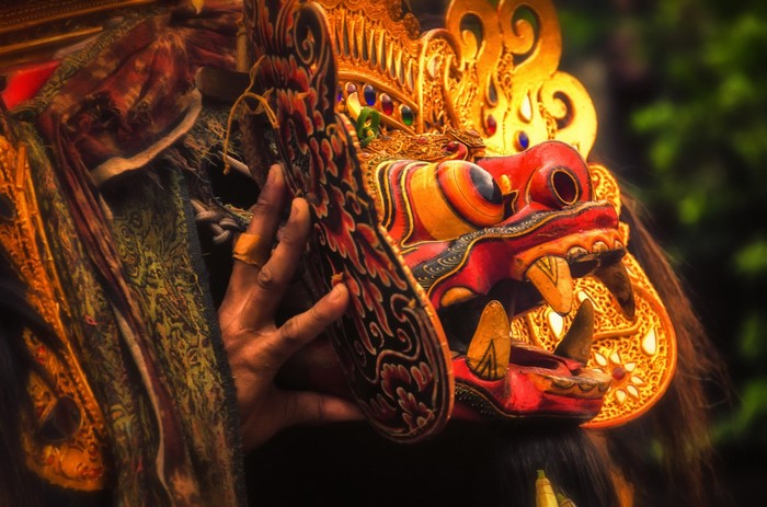 Balinese mask with golden headdress and human hand