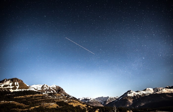 Starry night sky over snow-capped mountains