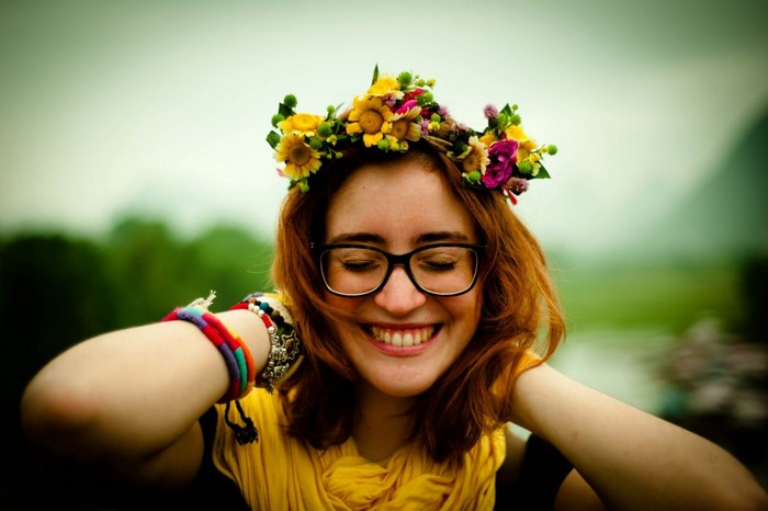Woman with flower crown and glasses smiling