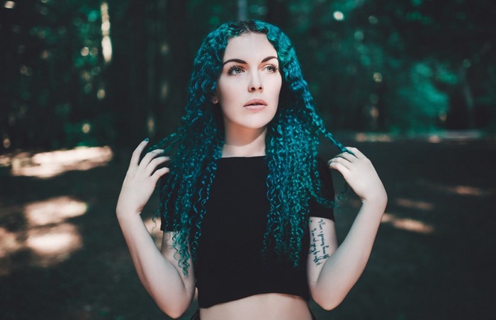 Woman with blue curly hair and tattoo
