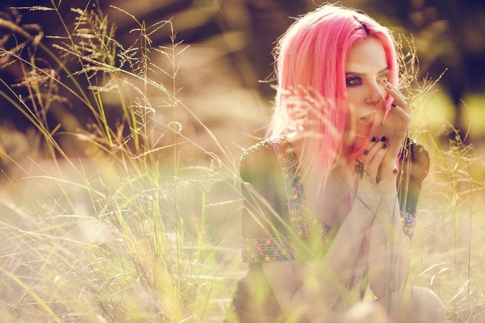 Woman with pink hair in a field