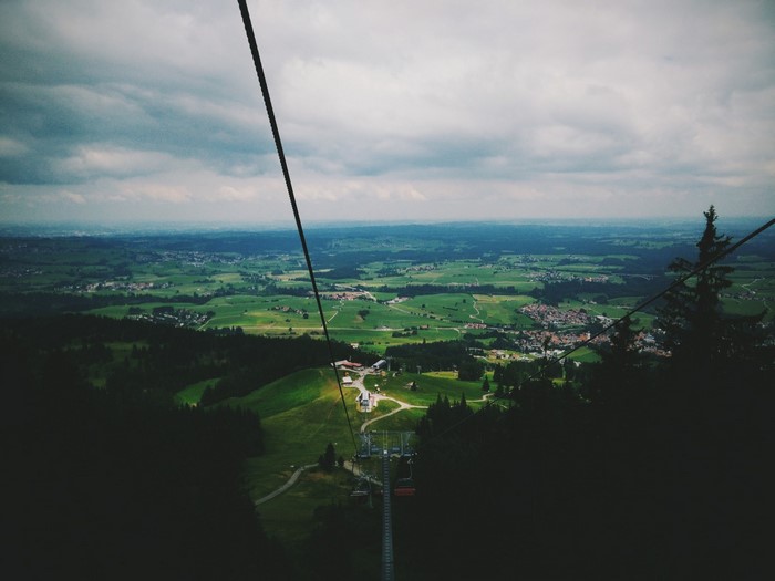 View from a ski lift over a green valley